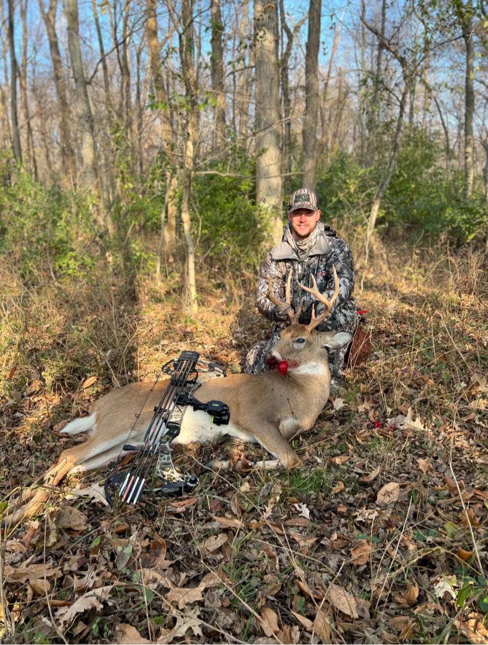 Hunter Mears in the woods with a whitetail buck taken with his bow